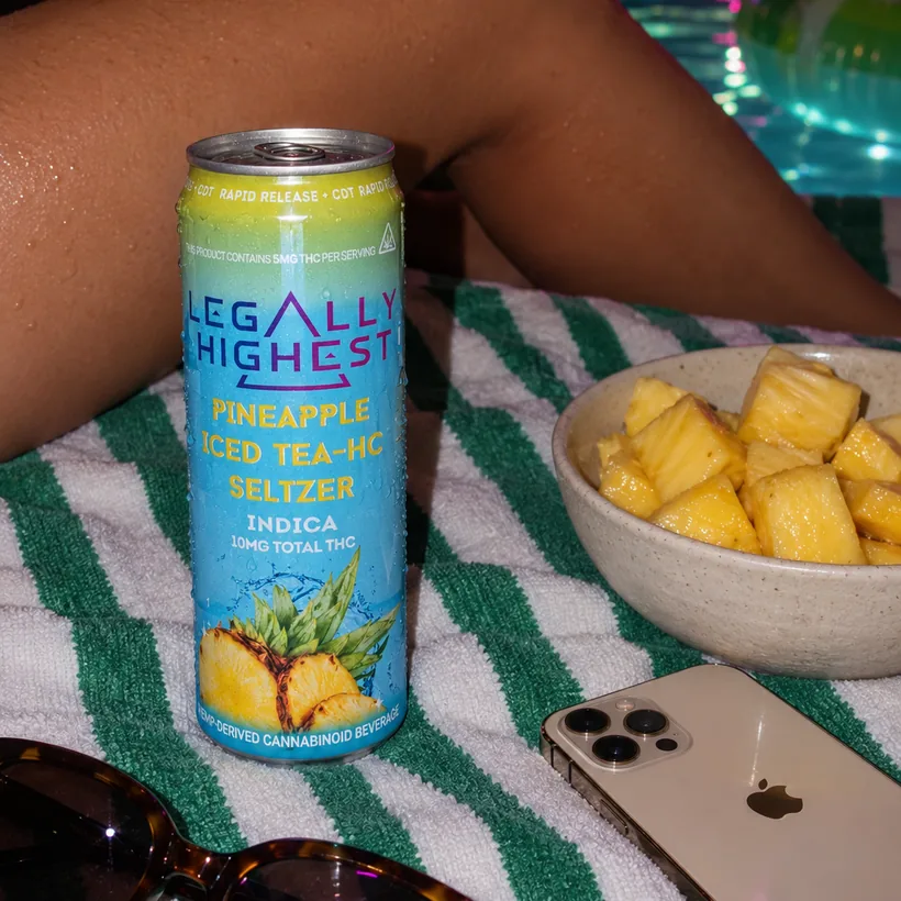 A can on a towel by the pool at night